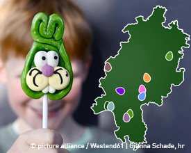 Junge mit Osterhasen-Lutscher und daneben eine Hessen-Karte.