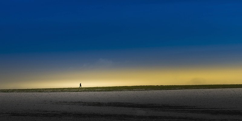 Ein Mensch läuft auf einem einsamen Strand 