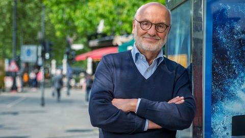 Michael Corssen lehnt an einer Wand mit übereinandergeschlagenen Armen