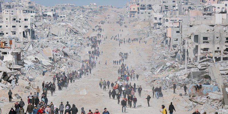 Menschen ziehen durch das zerstörte Gaza City, rechts und links Ruinen der ehemaligen Häuser