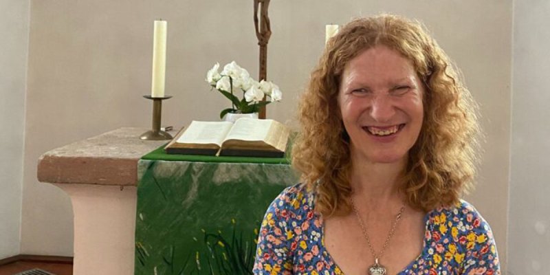 die Vikarin Brigitte Buchsein im Sommerkleid vor dem Altar