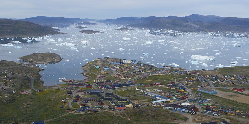 Luftaufnahme des Küstenstädtchens Narsaq mit Eisschollen 